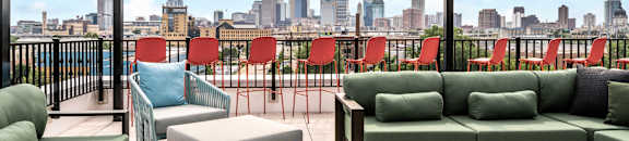 a living room with green couches and chairs and a view of the city
