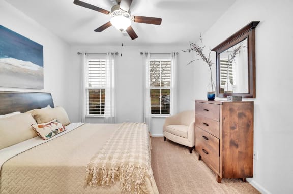 a bedroom with a bed and a ceiling fan