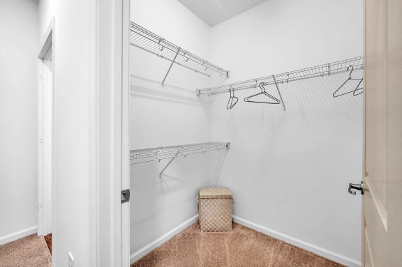 a closet with a basket and hanging racks