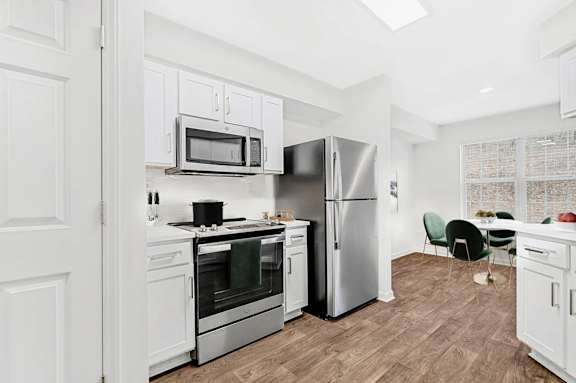 A kitchen with white cabinets and stainless steel appliances.