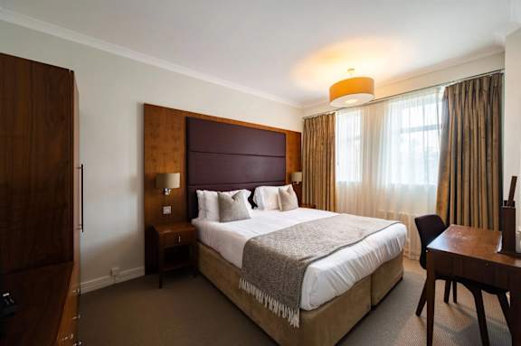 A bedroom with a large bed and a wooden headboard.