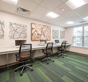 A room with a green carpet and a painting on the wall.
