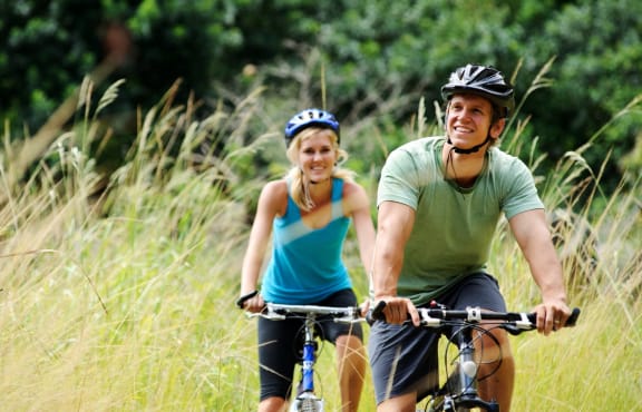 Man and Woman Smiling while Riding Bikes