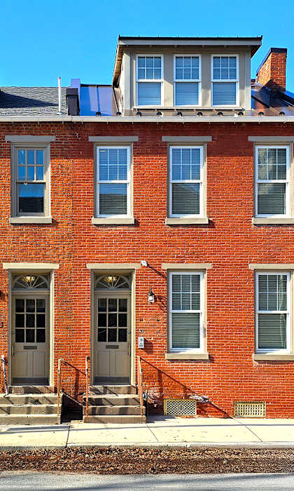A red brick house with a black door and windows.