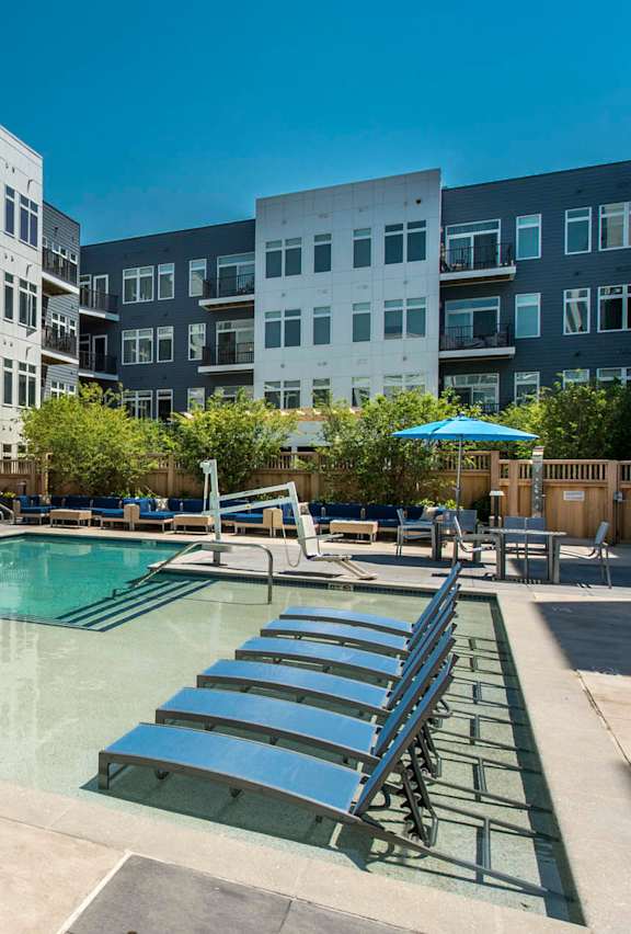 an apartment building with a swimming pool and lounge chairs