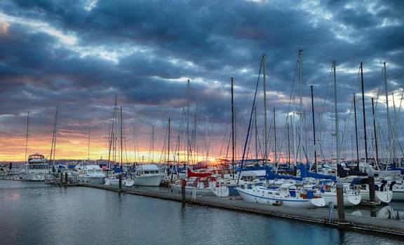A marina filled with boats at sunset.