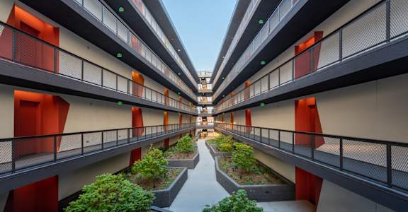 an inner courtyard of an apartment building with trees and plants