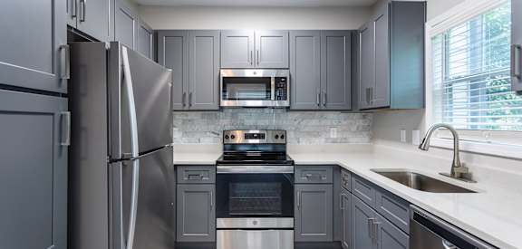A modern kitchen with a stainless steel refrigerator and oven.