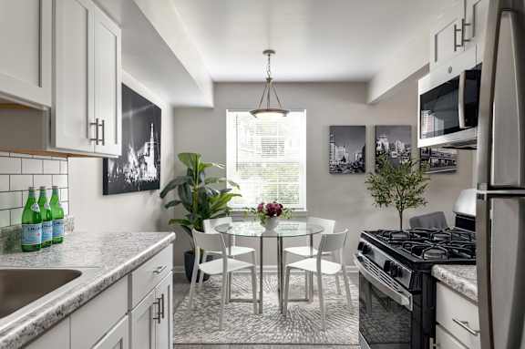 A modern kitchen with a dining table and chairs.
