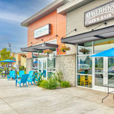 A Mavericks Men's Hair salon with blue chairs and umbrellas outside.