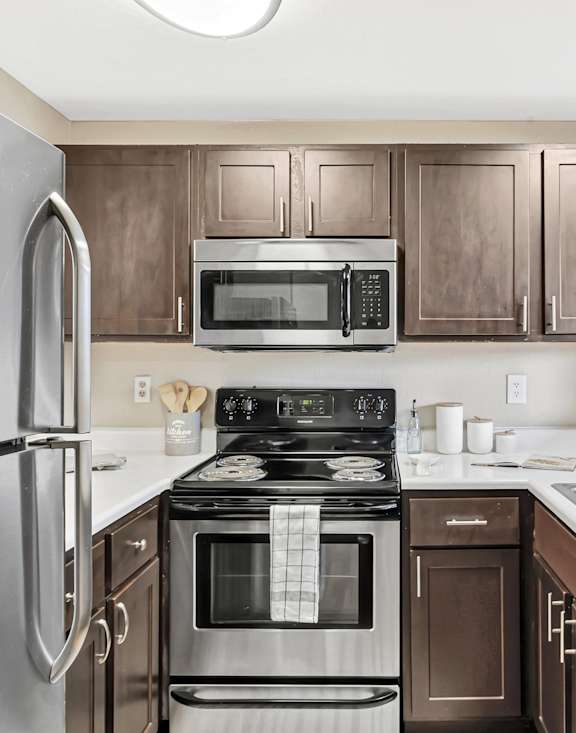 A kitchen with a stove, oven, microwave, and refrigerator.
