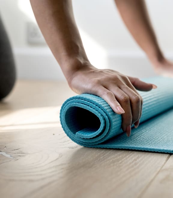 a person rolling up a yoga mat