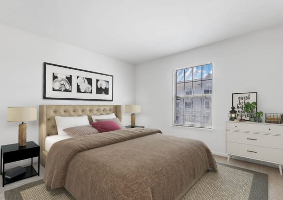 a bedroom with a large bed in front of a window at Brownstones, Novi, MI