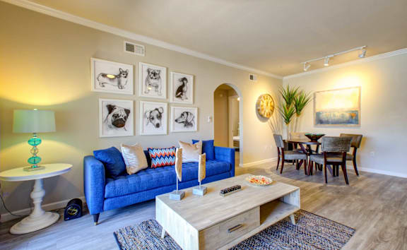 A living room with a blue couch and a wooden coffee table.
