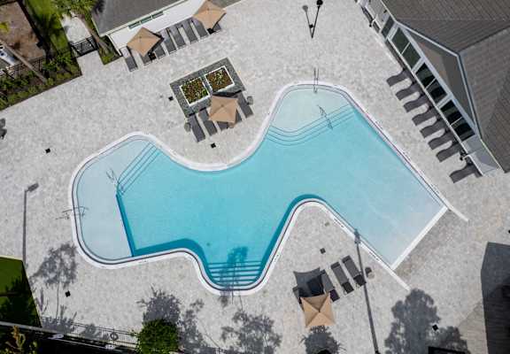 A large outdoor swimming pool surrounded by a patio area.