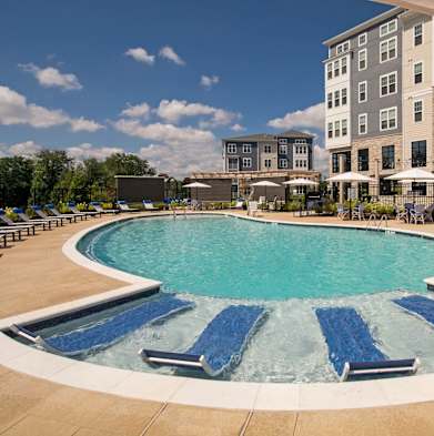 a large swimming pool in front of an apartment building