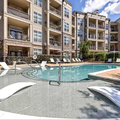 A swimming pool in front of apartment buildings.