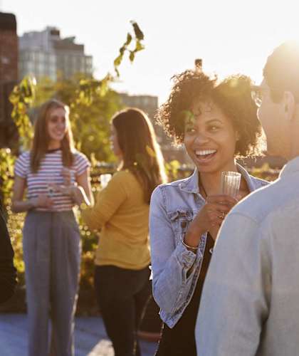 a group of people talking and laughing at a party