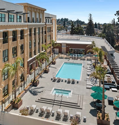 A large apartment complex with a pool and a covered patio.