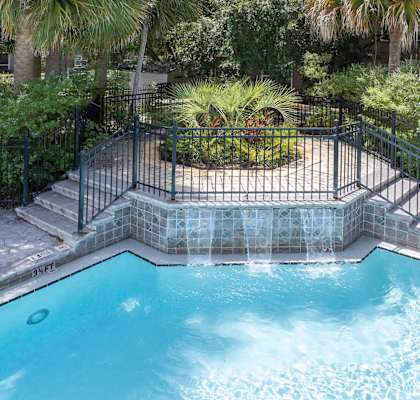 A small pool surrounded by a black fence.