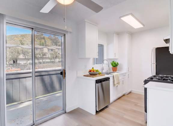 A kitchen with a stainless steel dishwasher and a black stove top oven.