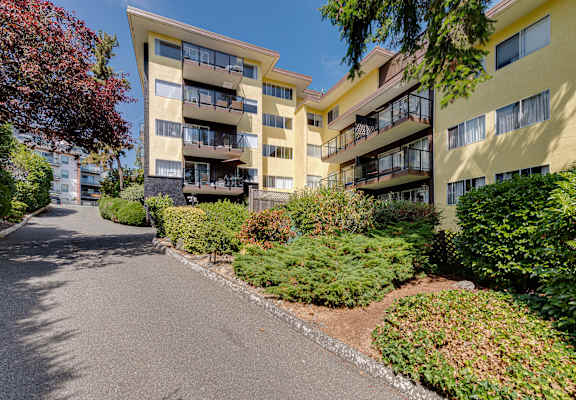 Apartment building with a paved road in front.