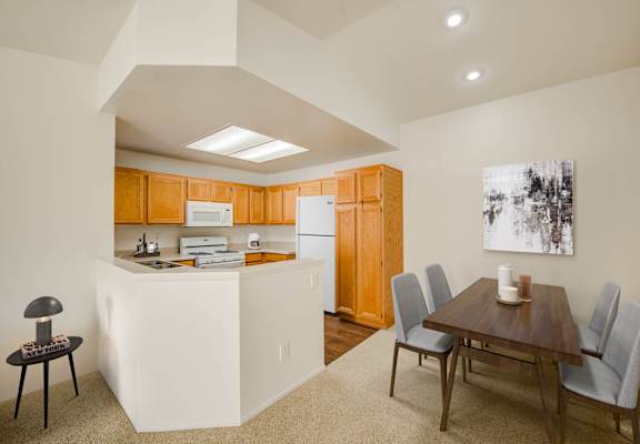 a kitchen and dining room with a wooden table and chairs