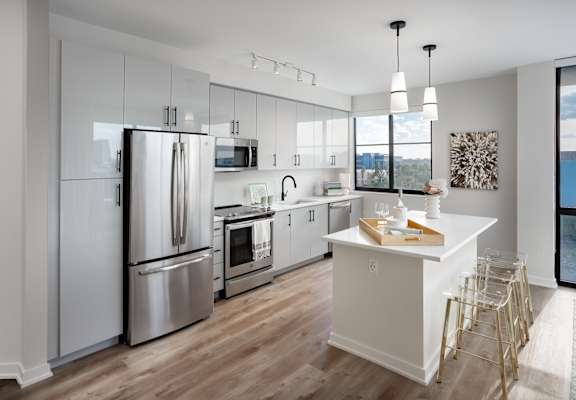 a kitchen with white cabinets and stainless steel appliances