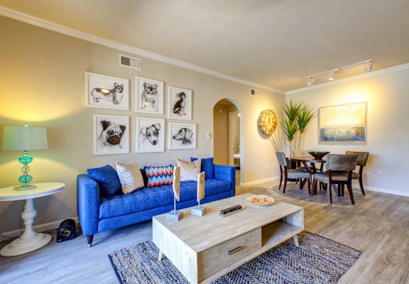 A living room with a blue couch and a wooden coffee table.
