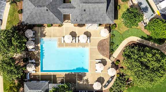 a birdseye view of a house with a large pool in the backyard