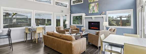 A living room with a brown sofa and a fireplace.