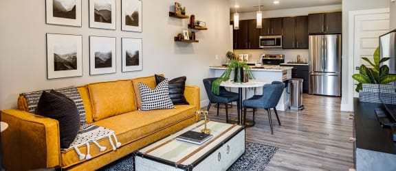 a kitchen with a long island with green chairs at Icon Apartment Homes at Ferguson Farm, Bozeman, Montana
