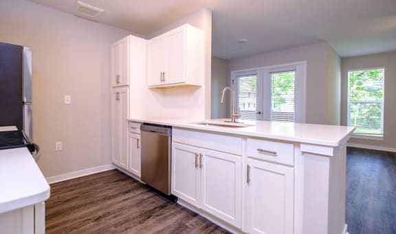 a kitchen with white cabinets and a stainless steel dishwasher