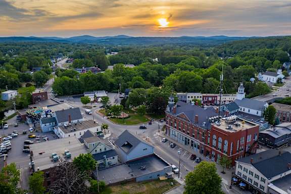 A sunset view of a small town with a church and buildings.
