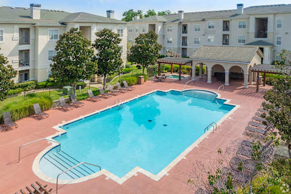 A large swimming pool surrounded by apartment buildings.