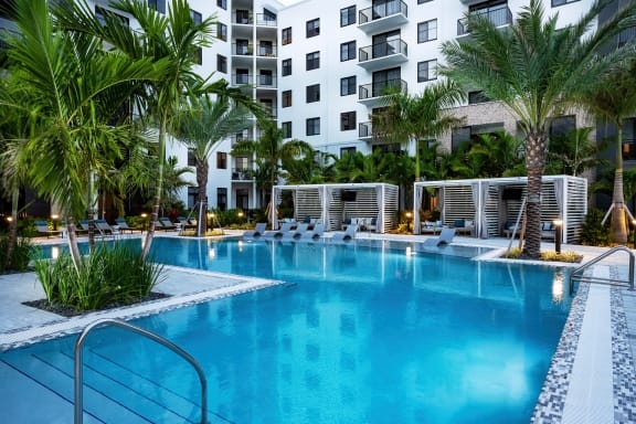 a large swimming pool with a white building in the background
