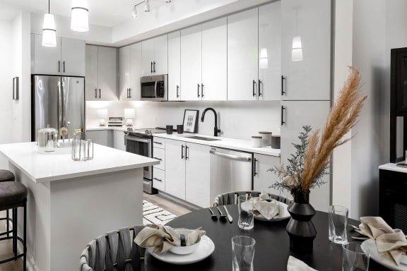 a kitchen with white cabinets and a black table