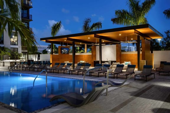 a swimming pool with chaise lounge chairs and a poolside bar