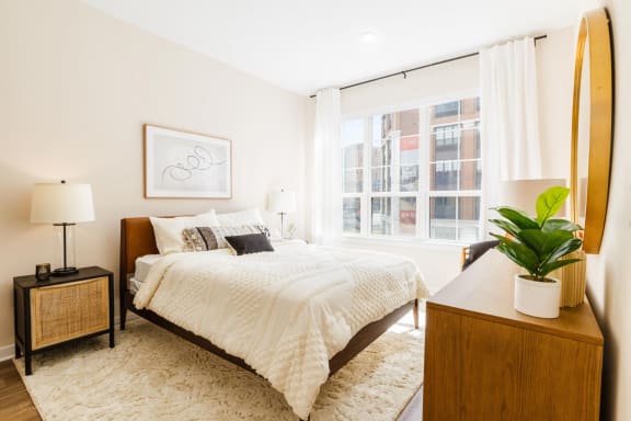 a bedroom with a bed and a large window at One Ten Apartments, New Jersey, 07310