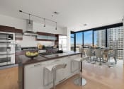 Thumbnail 13 of 17 - a kitchen with a large center island with a breakfast bar and a dining room with a table