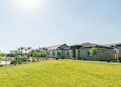Thumbnail 3 of 5 - A row of houses with green lawns in front.