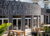 Thumbnail 8 of 9 - the facade of the building with tables and chairs