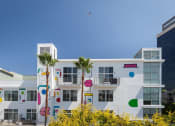Thumbnail 3 of 9 - a building with palm trees and circles painted on it