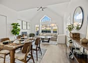 Thumbnail 1 of 8 - A dining room with a table set for six and a couch in the background.