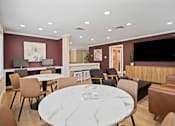 Thumbnail 2 of 5 - A modern dining room with a marble table and chairs.