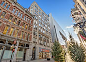 Thumbnail 1 of 7 - A street view of a city with a mix of old and new buildings.