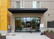 Thumbnail 12 of 16 - A building with a glass door entrance and a sign that says "Welcome to the community.".