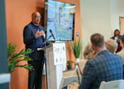 Thumbnail 3 of 16 - A man is giving a speech at a podium with a banner that reads "Copper".