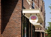 Thumbnail 5 of 14 - a pink and white sign on the side of a brick building