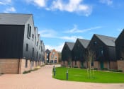 Thumbnail 5 of 8 - a row of houses on a street with green grass